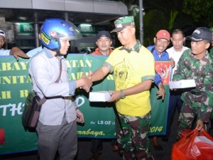 Dandim 0832/Surabaya Selatan (pakai kaos kuning) membagikan nasi kotak untuk sahur kepada seorang pengendara yang melintas di depan halte bus RSI. (FOTO : parlin/surabayaupdate.com)