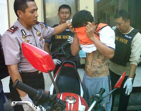 Kapolsek Sukolilo, Kompol Taufik Yulianto (kiri) memamerkan tato tersangka curanmor yang berhasil ditangkap polisi PJR Jembatan Suramadu. (FOTO : parlin.surabayaupdate.com)