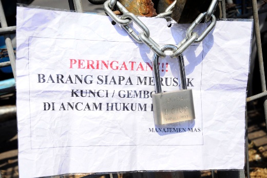 Kertas peringatan yang tertempel pada pagar yang terkunci dengan gembok memicu amarah sejumlah PKL Pagesangan yang biasanya mencari nafkah dengan berjualan di lahan kosong samping Masjid Agung Surabaya. (FOTO : hercox untuk surabayaupdate.com)